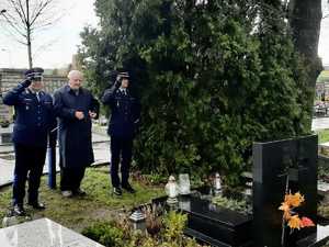 Komendanci przed grobem Ludwikowskiego zapalają znicz