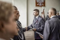Zastępca Komendanta Wojewódzkiego i Przewodniczący związków zawodowych wręcza akty mianowania policjantom